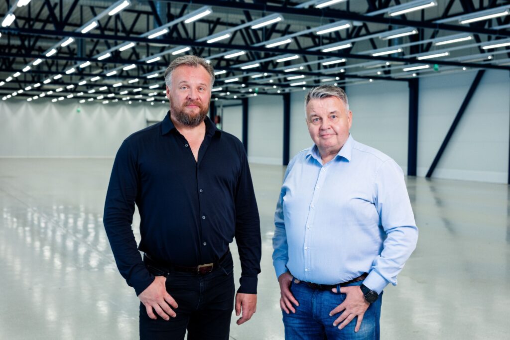 Kaksi miestä isossa tyhjässä hallissa.